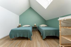 Habitación con 2 camas, paredes azules y suelo de madera. en Gite Cascades du Hérisson 3 chambres piscine en La Châtelaine