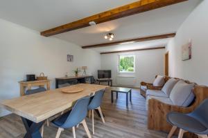 a living room with a wooden table and a couch at Gite Chateau 3 chambres piscine chauffée in La Châtelaine