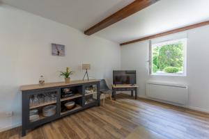 a living room with a table and a television at Gite Chateau 3 chambres piscine chauffée in La Châtelaine +21 photos