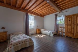 a bedroom with two beds and a large window at Gite Chateau 3 chambres piscine chauffée in La Châtelaine