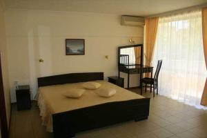 1 dormitorio con cama, escritorio y mesa en Hotel Klisura en Sunny Beach