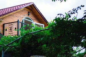 una piccola casa con finestra e balcone di Dzama Guest House a Ort'ubani