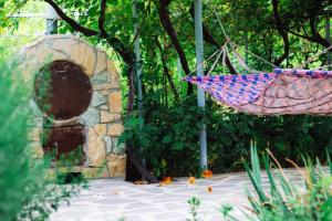 een hangmat hangt voor een stenen deuropening bij Dzama Guest House in Ort'ubani