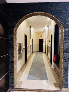 a hallway with a tile floor and an archway at اصالة الشروق للشقق المخدومه in Al Khobar