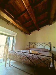 - une chambre avec un lit et un plafond en bois dans l'établissement Il Rifugio sul Colle - Casa vacanze a Campo Felice, à Casamaina