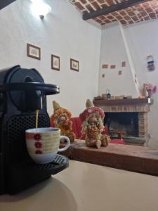 una macchinetta del caffè e orsacchiotti seduti accanto a una tazza di caffè di Il Rifugio sul Colle - Casa vacanze a Campo Felice a Casamaina