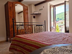 - une chambre avec un lit et une grande fenêtre dans l'établissement Il Rifugio sul Colle - Casa vacanze a Campo Felice, à Casamaina