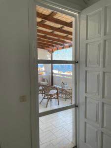 una puerta abierta a un patio con mesa y sillas en 180° View to Sea, en Vathí