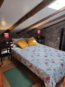 a bedroom with a bed with a floral blanket and two lamps at Casa di Volce - 1801 Stone House in Tolmin