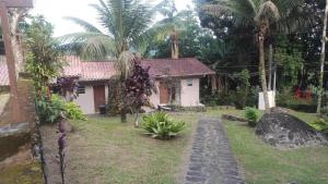 a house with a palm tree in front of a yard at Chalés Carioca Prumirim Ubatuba in Ubatuba