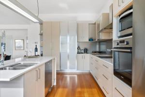 a kitchen with white cabinets and stainless steel appliances at Stunning newly renovated home in perfect location in Hobart