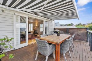 une terrasse avec une table et des chaises en bois. dans l'établissement Stunning newly renovated home in perfect location, à Hobart