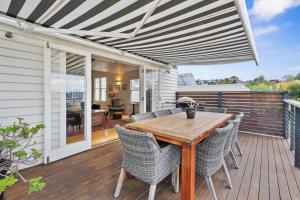 a patio with a wooden table and chairs on a deck at Stunning newly renovated home in perfect location in Hobart
