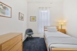 a bedroom with a bed and a desk and a chair at Stunning newly renovated home in perfect location in Hobart