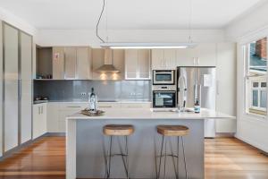 a kitchen with a counter and stools in it at Stunning newly renovated home in perfect location in Hobart