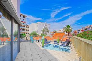 un patio con sedie e tavoli su un balcone di Appartement Terrasse vue Mer a Canet-en-Roussillon