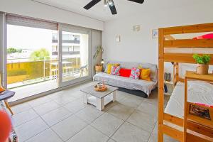 a living room with a couch and a bunk bed at Studio moderne avec parking et piscine- 313 in Canet-en-Roussillon
