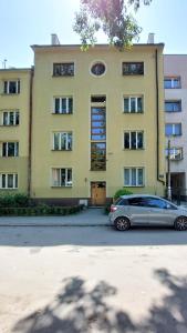 克拉科夫的住宿－Apartament 1A，停在黄色建筑前面的汽车