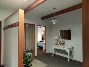 a bedroom with a bed and a desk and a mirror at Large, Comfy, Stylish Apartment in Havelock North