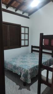 a bedroom with two bunk beds and a window at Chalés Carioca Prumirim Ubatuba in Ubatuba