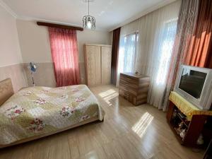 a bedroom with a bed and a tv in it at Дом с 5 спальнями в Батуми in Batumi