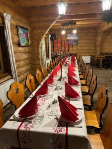 una mesa larga con servilletas rojas y gafas. en Viesu nams Vālodzes, en Sigulda