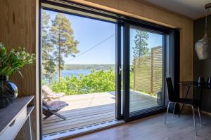 a kitchen with a sliding glass door with a view of the water at Lekkert gjestehus ved sjøen 