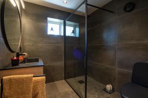 a bathroom with a shower with a sink and a mirror at Lekkert gjestehus ved sjøen 