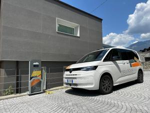 un furgone bianco parcheggiato di fronte a un edificio di 21Barra5 Guest House ad Aosta