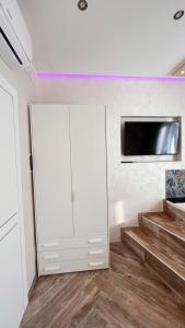 a room with a white cabinet and a tv on a wall at Suites Matteotti 57 in Civitavecchia