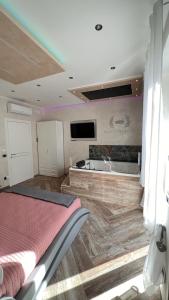 a room with a bed and a tub and a tv at Suites Matteotti 57 in Civitavecchia