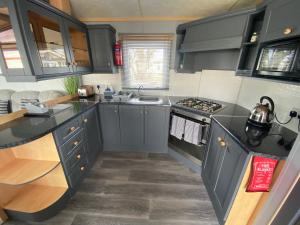 una cocina con armarios grises y fregadero en Golden Palm - Sherwood 472 - S472 en Skegness