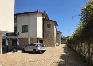 un pequeño coche plateado estacionado frente a un edificio en Апартхотел Созополски перли, en Sozopol