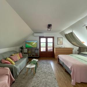 a attic bedroom with two beds and a couch at Panorama Wine & Chill in Hévíz