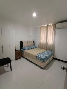 a bedroom with two beds and a dresser in it at Three-Bedroom Holiday Home - 4th Floor Stairs Only in Mactan