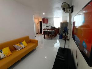 uma sala de estar com um sofá e uma cozinha em Three-Bedroom Holiday Home - 4th Floor Stairs Only em Mactan