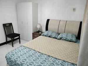um quarto com uma cama grande e uma cadeira em Three-Bedroom Holiday Home - 4th Floor Stairs Only em Mactan