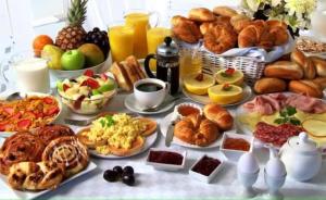 una mesa cubierta con muchos tipos diferentes de alimentos para el desayuno en Villa Peonia, en Keszthely