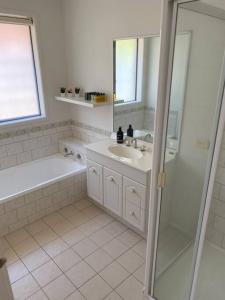 a white bathroom with a sink and a shower at Open 4 bedroom home in Warrnambool