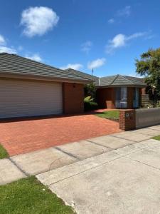 a house with a brick driveway in front of it at Open 4 bedroom home in Warrnambool