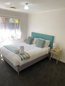 a bedroom with a large bed and a window at Open 4 bedroom home in Warrnambool