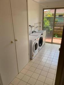 a washing machine in a room with a window at Open 4 bedroom home in Warrnambool
