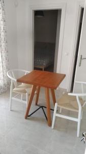 PotamósにあるAVRA-2 Apartments Potamos CORFUの木製テーブルと椅子