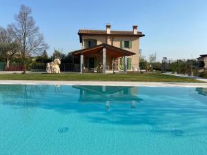 a house with a large pool of water in front of a house at Poggio Bardolino in Bardolino