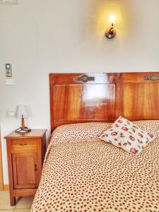 uma cama com uma cabeceira em madeira e uma almofada em Agriturismo Ceolara em Sommacampagna