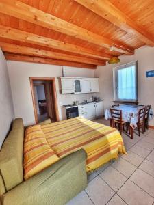 a bedroom with a bed and a kitchen with a table at Agriturismo Ceolara in Sommacampagna