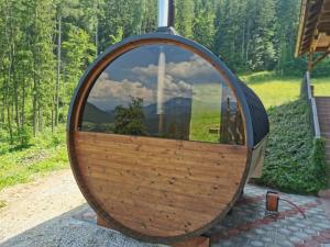 a large wooden circle with a mirror in it at Apartments Petek in Gornji Grad