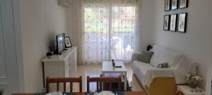 een woonkamer met een witte bank en een tafel bij Bonito piso en MarinaDor in Castellón de la Plana