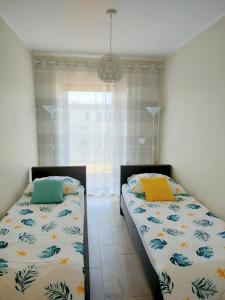 dos camas sentadas una al lado de la otra en un dormitorio en AURA Delux Seaside, en Dziwnów
