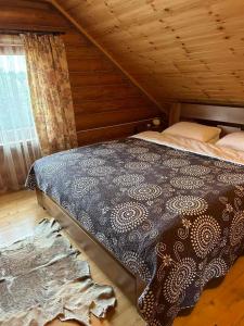 Bushtyno的住宿－Kazkova khatynka，木制客房内的一间卧室,配有一张床